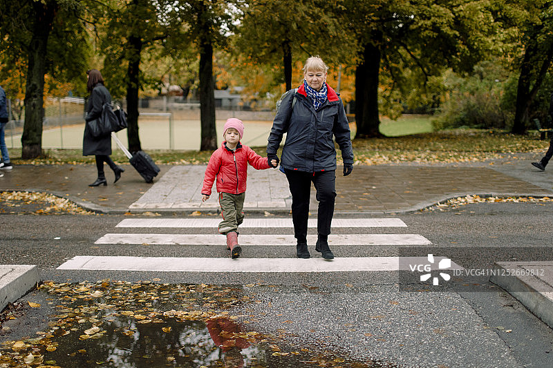 奶奶和孙子在城市的人行道上散步图片素材