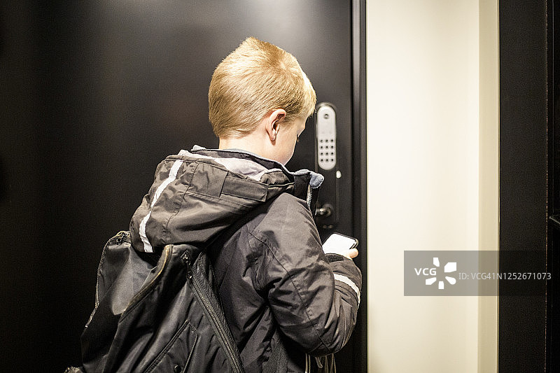 男孩用智能手机App开门背影图片素材