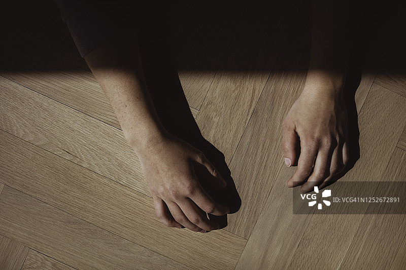 俯视角度拍摄的双手，位于硬木地板上图片素材