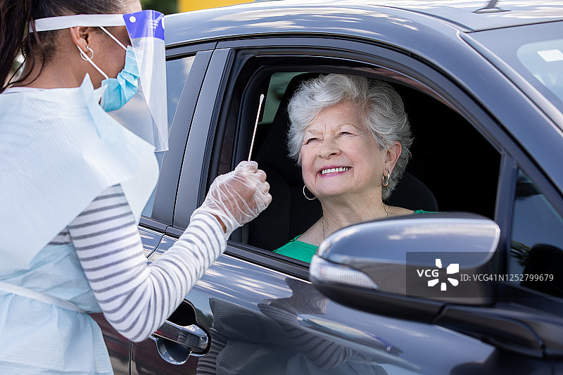 年长的女人在车内接受新冠病毒检测图片素材