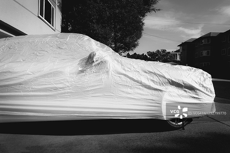 盖着布的汽车在车道上图片素材