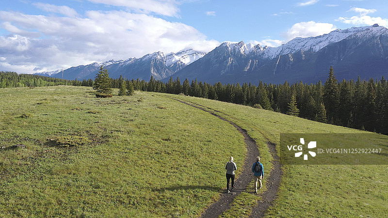 航拍：成熟情侣在乡村山路上徒步旅行图片素材