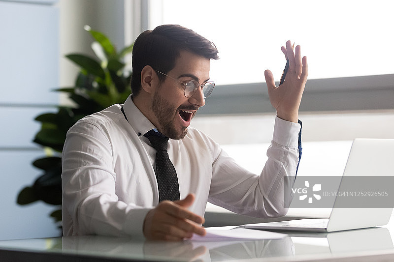 商人看笔记本电脑屏幕，感到惊喜并获得了好消息图片素材