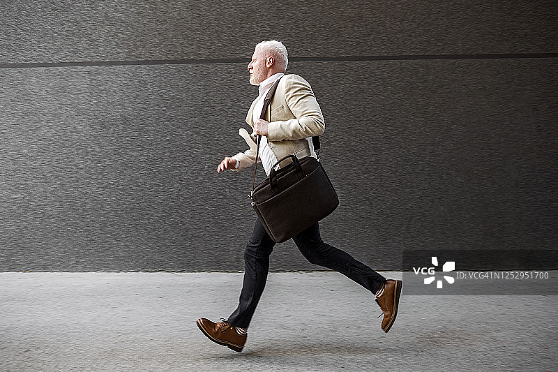 拿着笔记本电脑包奔跑的年轻白化病商人图片素材