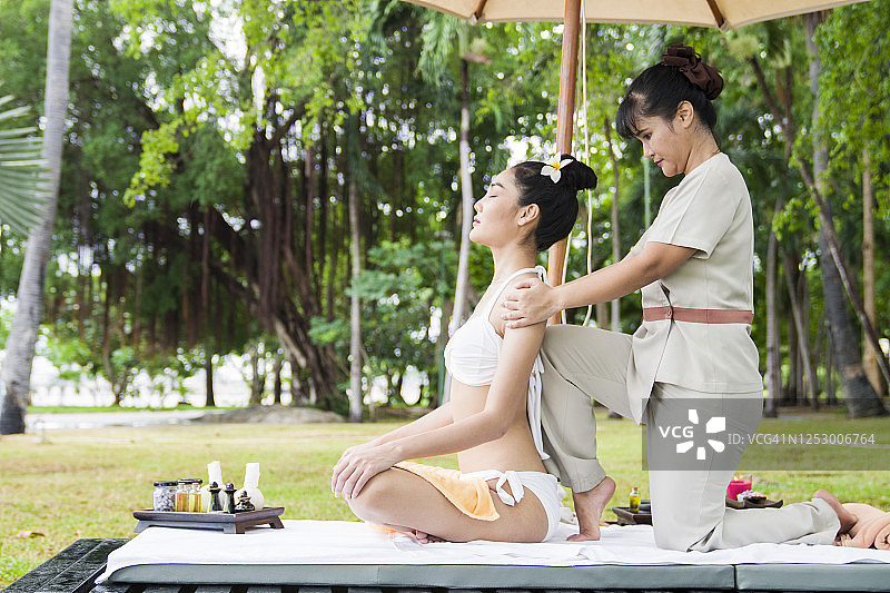 年轻女人在豪华度假胜地的阳台上接受按摩图片素材