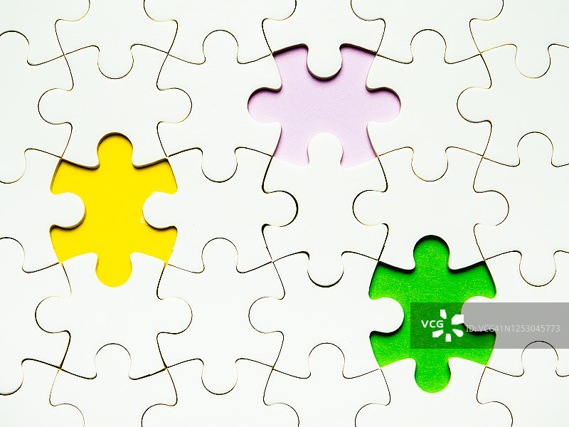 黄色、紫色和绿色背景上的白色缺块拼图图片素材