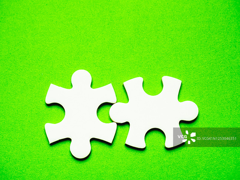 绿色背景上的白色拼图碎片图片素材