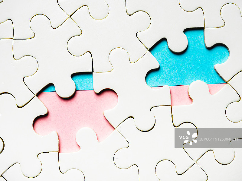 蓝粉色背景上缺少碎片的白色拼图图片素材