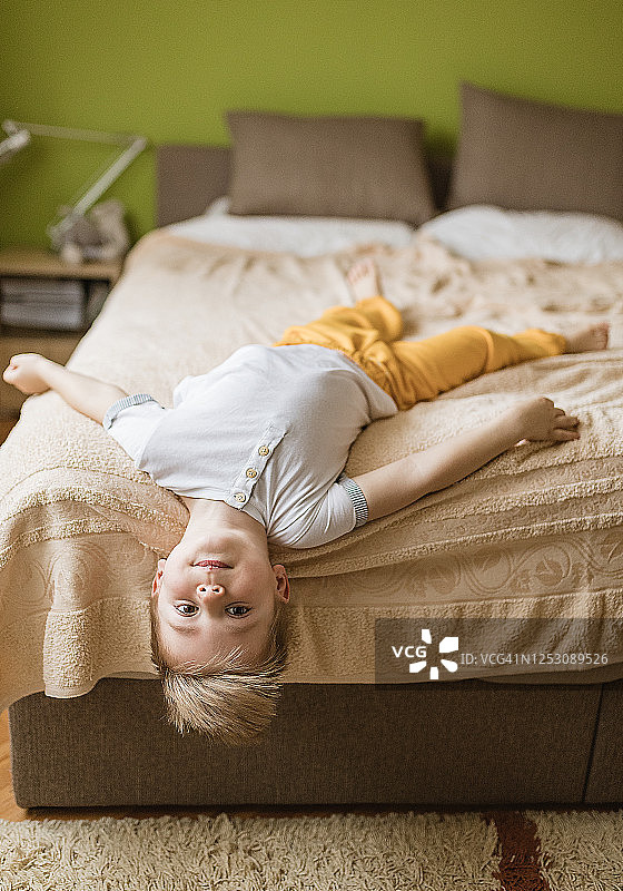 倒卧在床上的小男孩图片素材