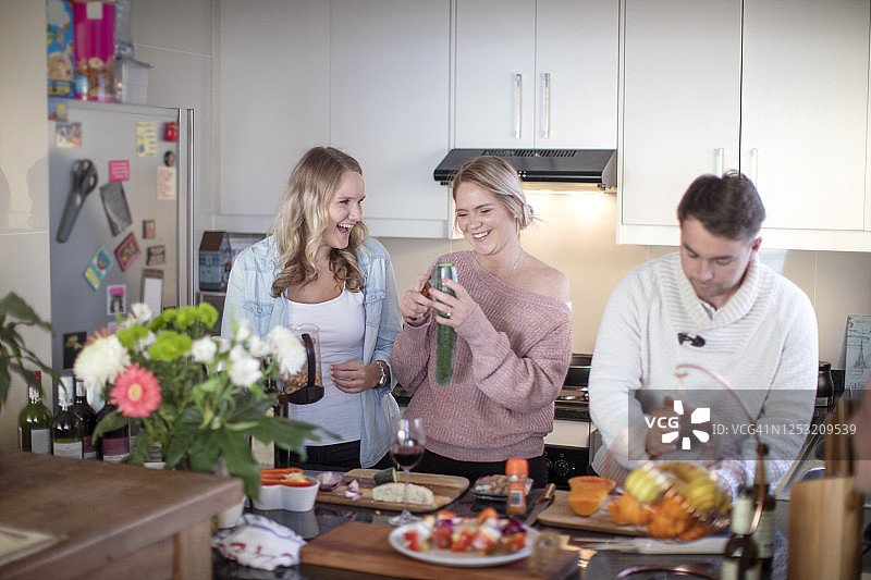 三个朋友在厨房一起做健康餐图片素材