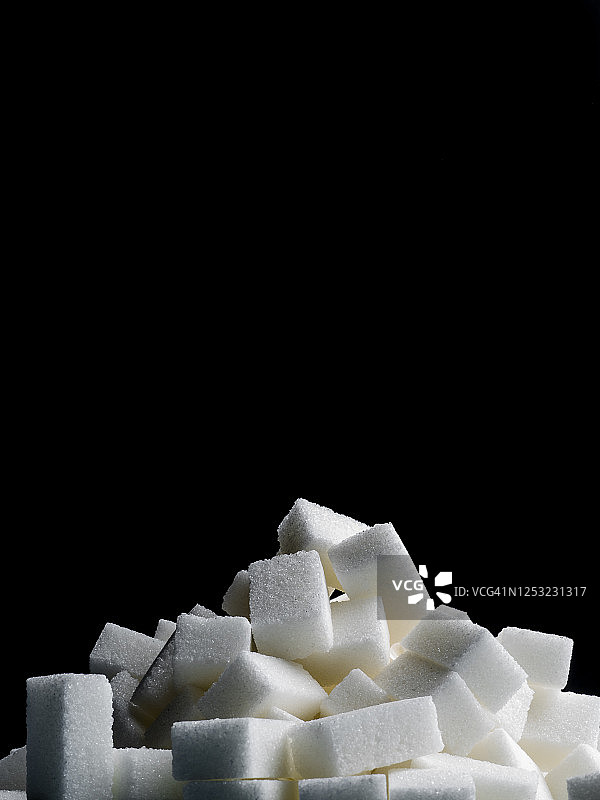 黑色背景上的糖块堆图片素材