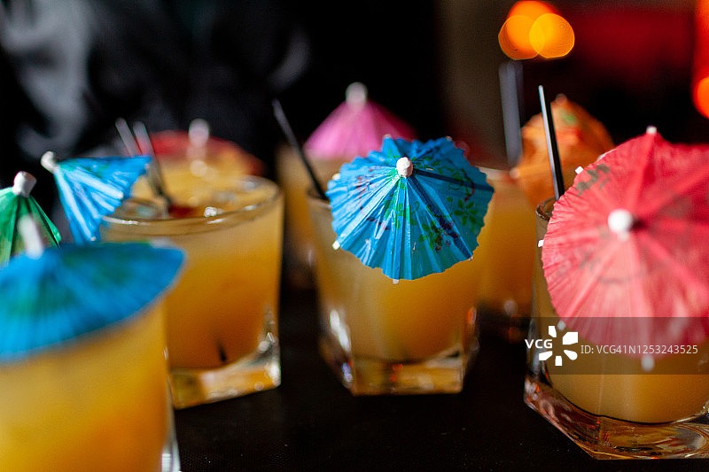 带彩色雨伞的黄色鸡尾酒图片素材
