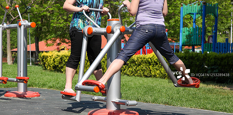 运动爱好者在城市公园使用健身器材训练图片素材