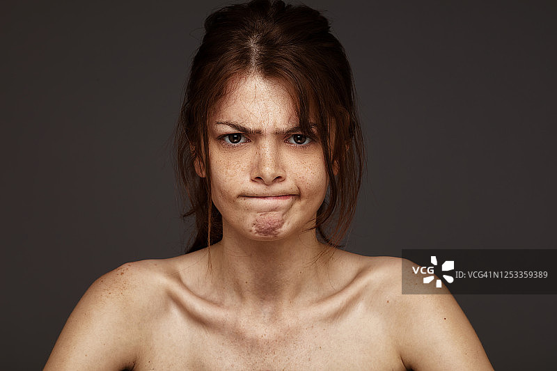 灰色背景前的雀斑美女肖像图片素材