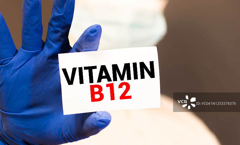 医生拿着一张写有维生素B12的卡片，医学概念图片素材