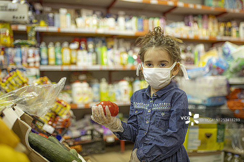 戴口罩去超市购物的小女孩图片素材