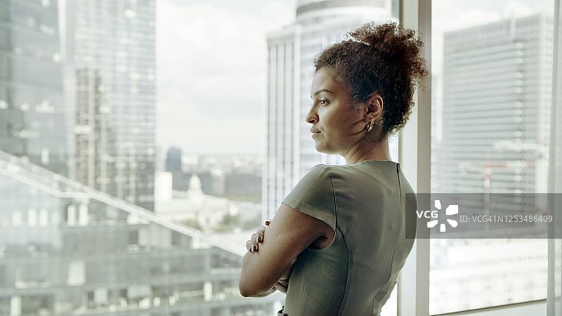 在办公室看风景的女商人图片素材