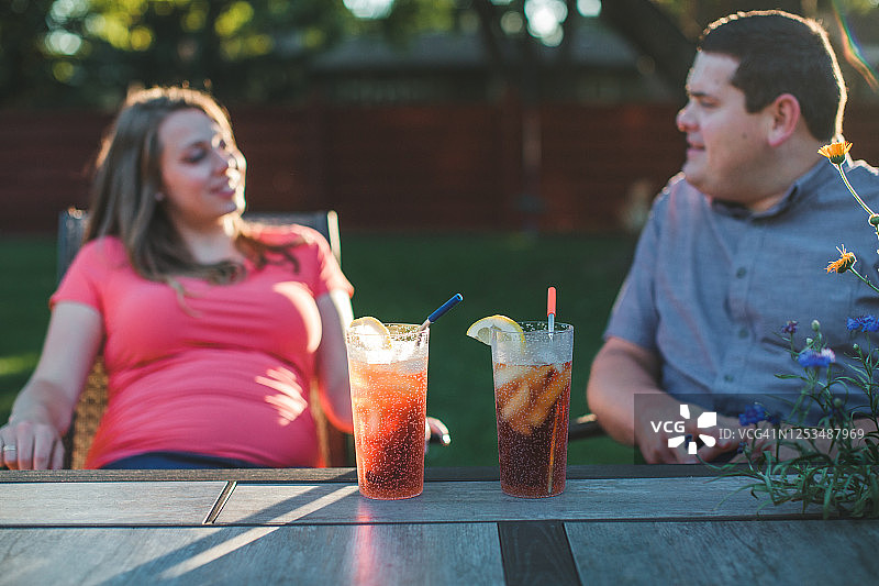 男人和怀孕的妻子放松地喝冰茶图片素材