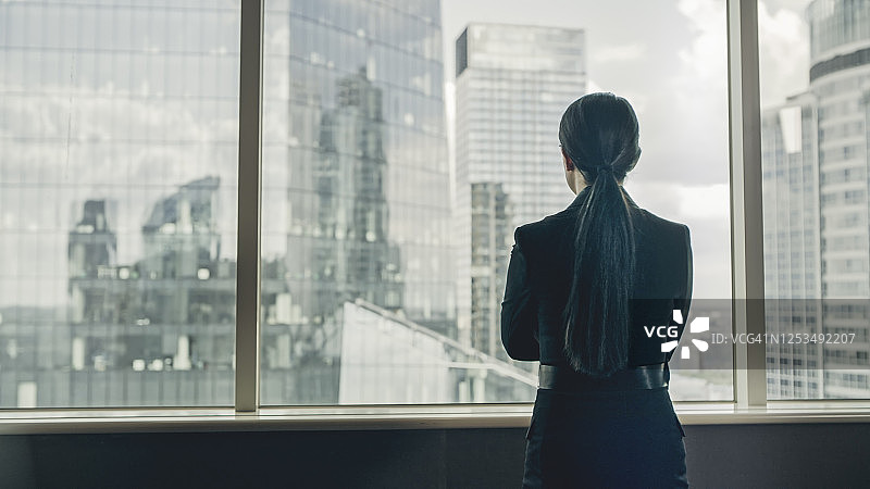 在办公室看风景的女商人图片素材