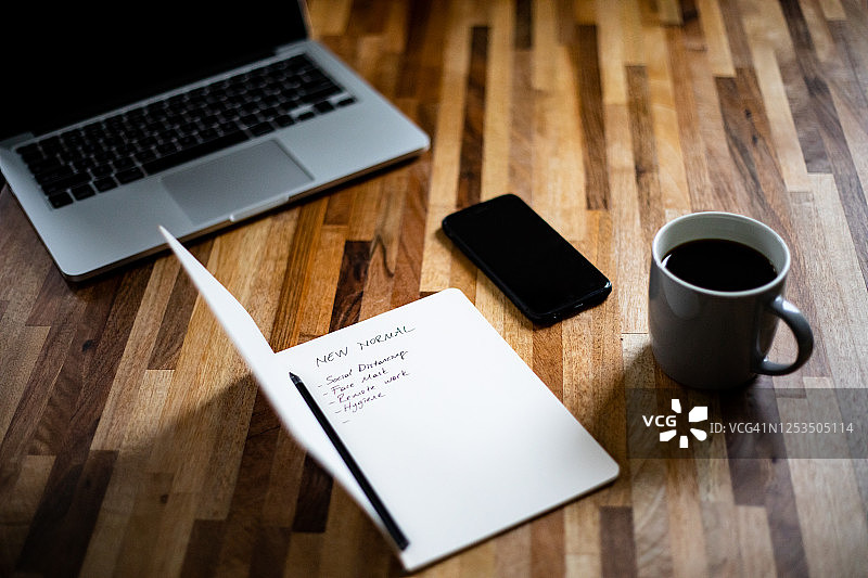 笔记本上手写“新常态”清单的特写图片素材