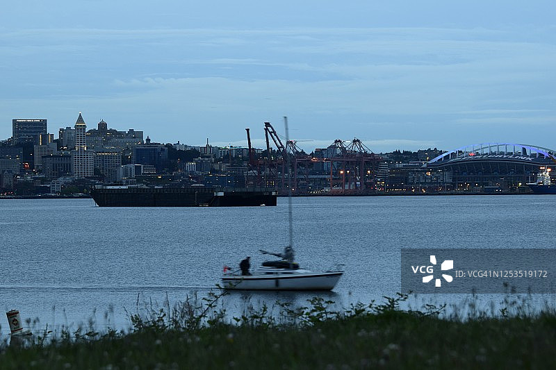 多云日出时从水对面看到的西雅图天际线和帆船图片素材