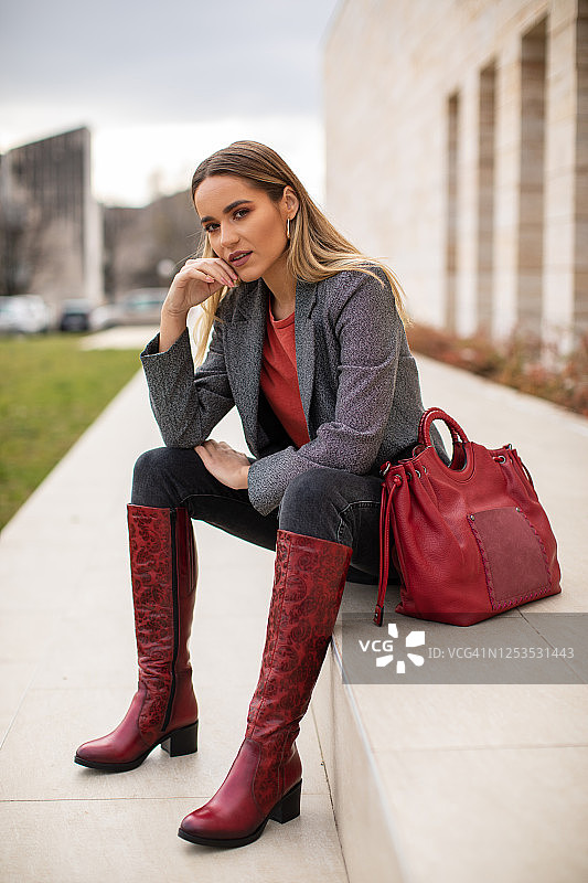 美丽的年轻女子在楼梯上放松图片素材