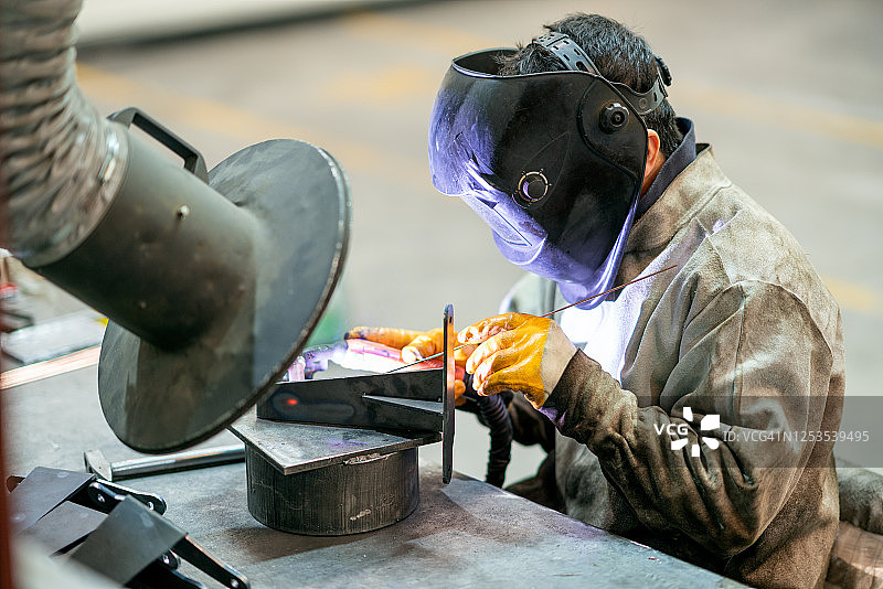 焊接工人在工厂工作图片素材