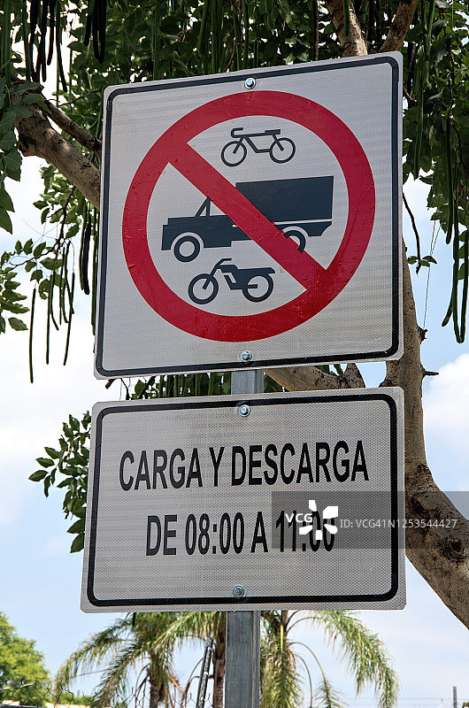 西班牙语交通标志：禁止自行车、卡车和摩托车通行，以及8:00至11:00装卸货物图片素材