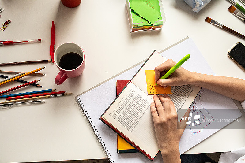 女人在家学习时在便签上记笔记图片素材