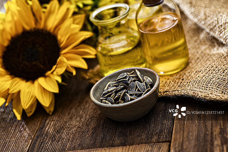 复古木纹上的向日葵籽与油图片素材