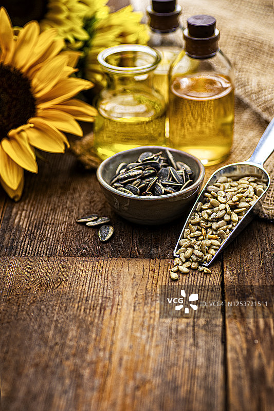 复古木纹上的向日葵籽与油图片素材