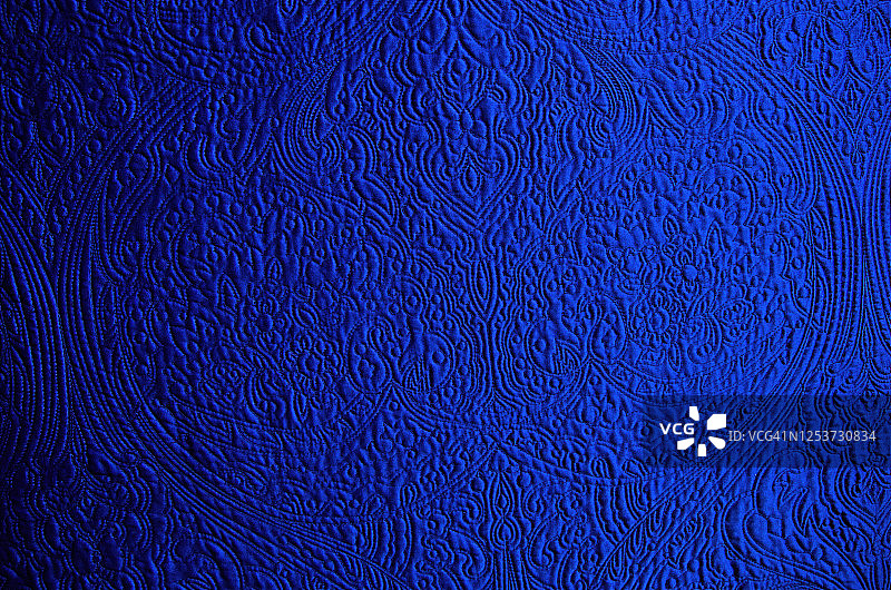 绗缝着华丽的新艺术风格花卉图案的宝蓝色床罩图片素材