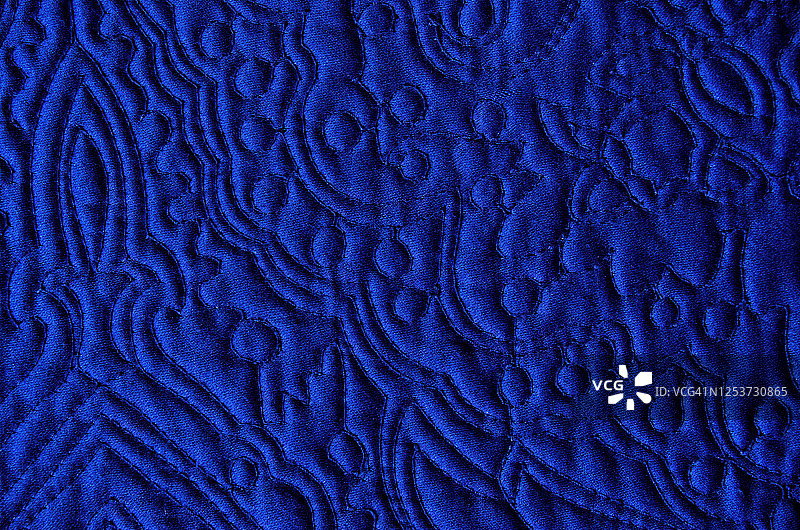 绗缝着华丽的新艺术风格花卉图案的宝蓝色床罩图片素材