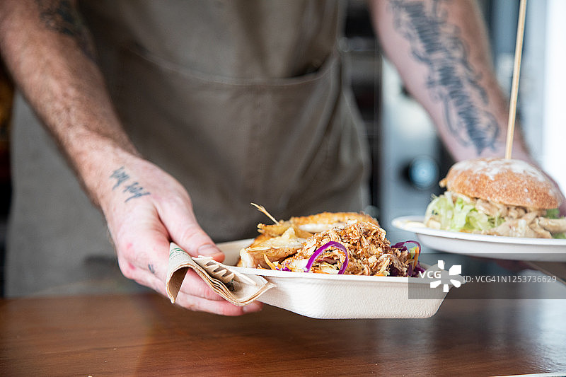 餐车供应的可降解餐盘烤鸡、沙拉和鸡肉汉堡图片素材