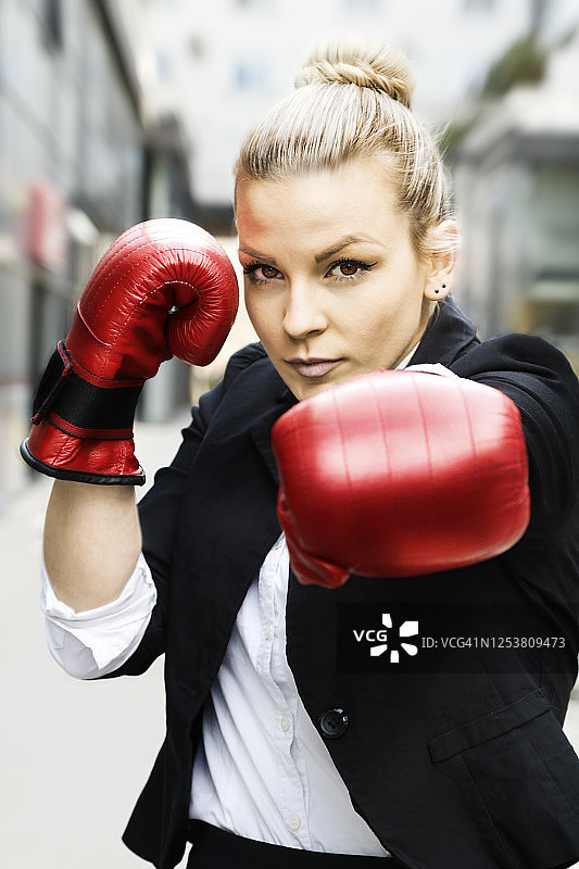 戴红色拳击手套的商务女性：为成功而战图片素材