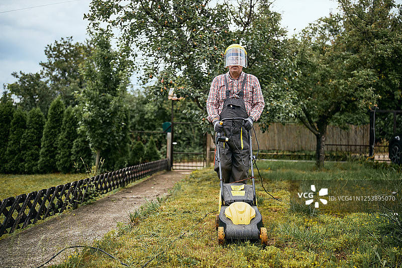 年长的男人在后院修剪草坪图片素材