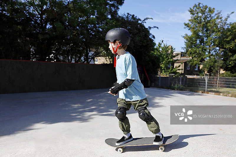 在公园学习滑板的男孩图片素材