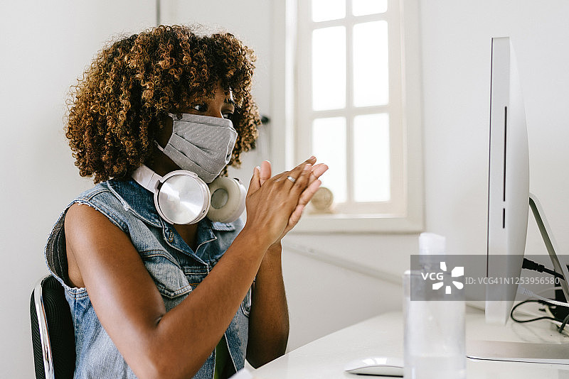 新冠疫情：办公室里的女人用酒精凝胶擦手图片素材