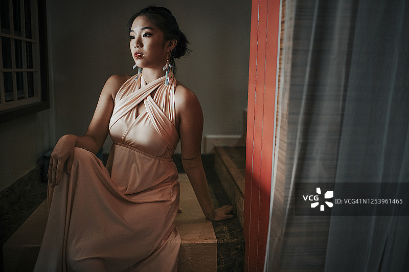 坐在楼梯上穿着晚礼服的中国少女图片素材