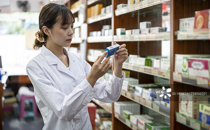 在药房工作的亚洲年轻女药剂师图片素材