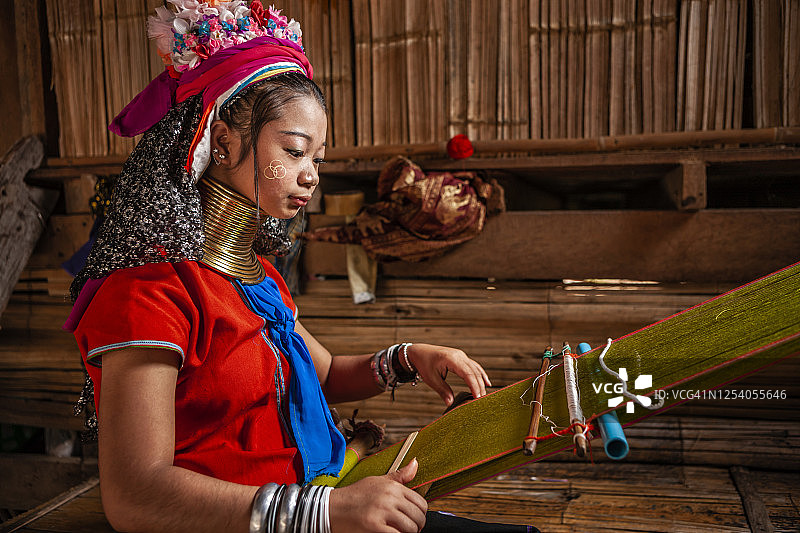 长颈喀伦族年轻女子在传统织布机上编织图片素材