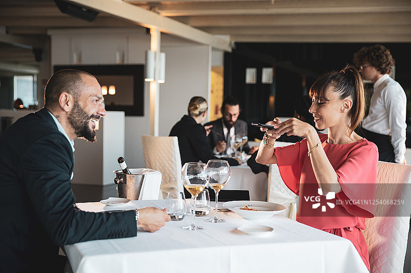 在餐馆拍照的女人图片素材