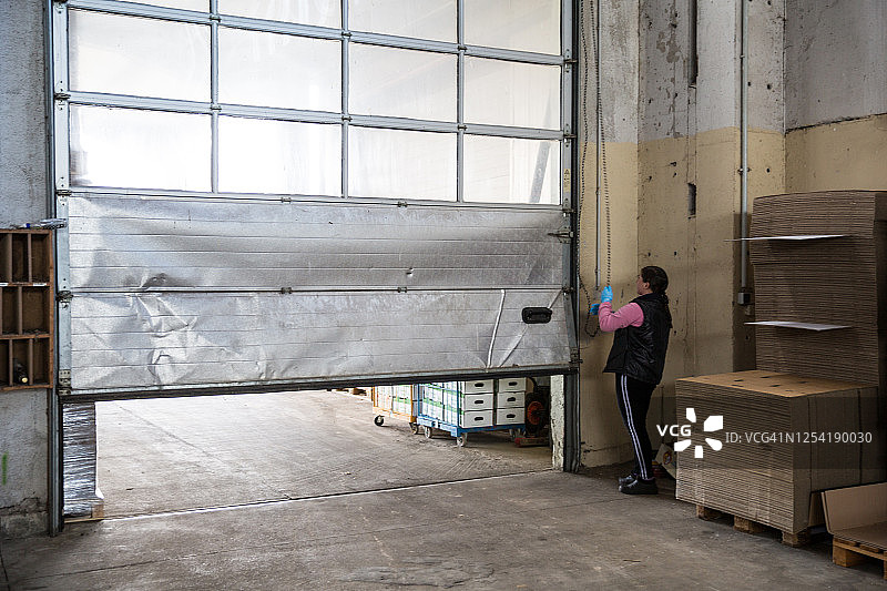 女工打开工业大厅的门图片素材