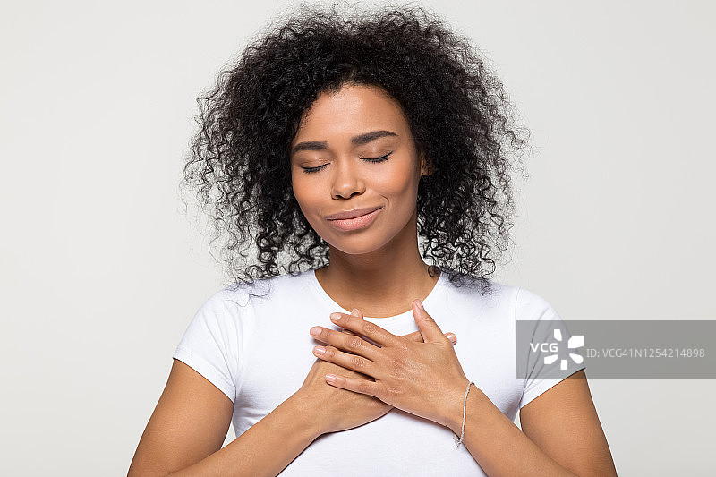 心怀感激充满希望的非洲裔美国妇女双手放在胸前图片素材