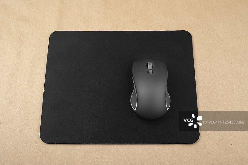 鼠标垫上的黑色无线鼠标图片素材