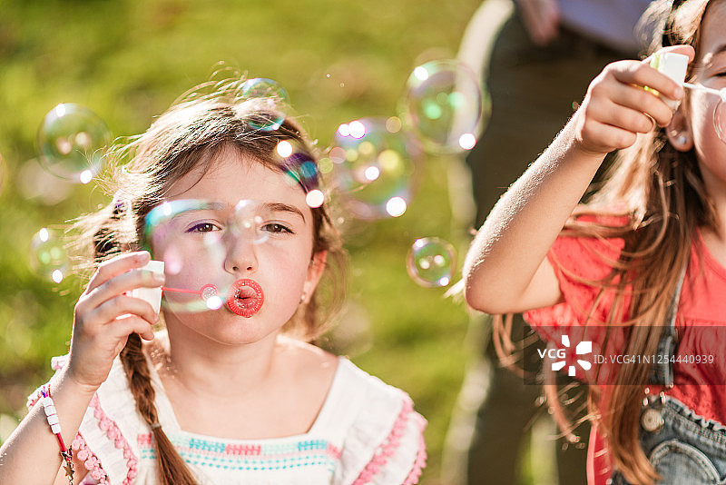 快乐的孩子们在公园里吹泡泡图片素材