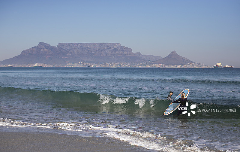 年轻夫妇在南非开普敦冲浪图片素材