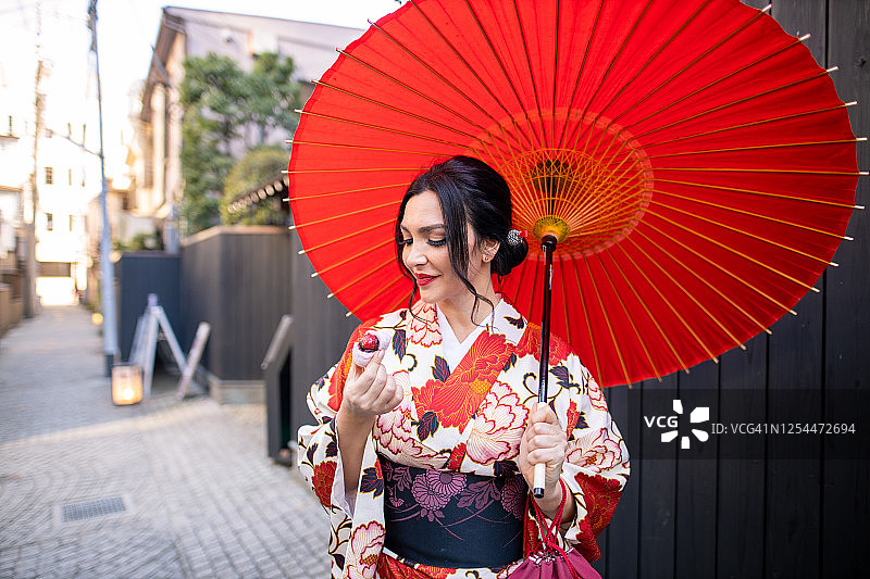 身穿和服的白人女性在吃草莓大福图片素材