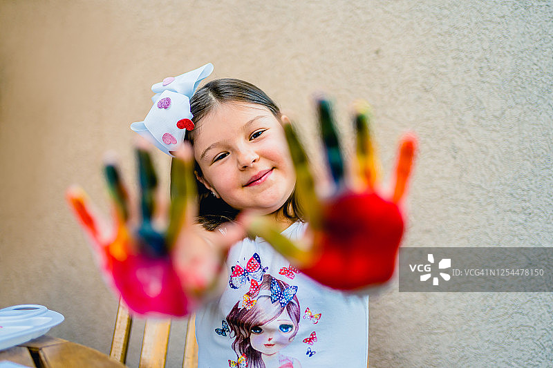 涂有手指画的可爱女孩展示双手图片素材
