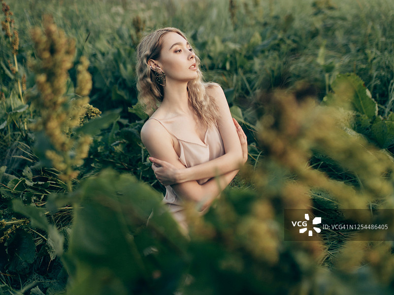 年轻漂亮的女子坐在草地上图片素材